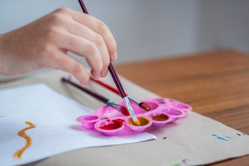 Girl painting with brush and colorful paint