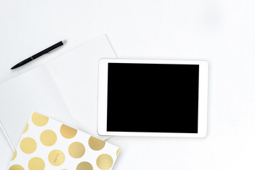 Flat lay photo of office white desk with tablet and gold notebook copy space background