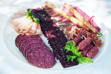Dish with sausage, salami and ham. The concept of food