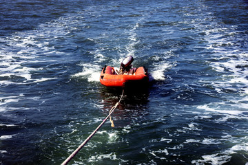 Inflatable dinghy with outboard motor at the wire
