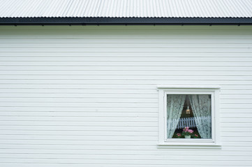 Side view of a white wooden house with small window