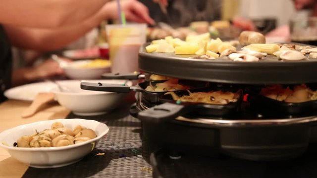 Gruppe von Freunden genie&szlig;t Raclette an Silvester