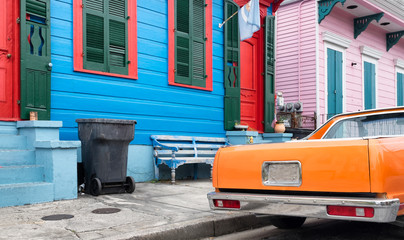 New Orleans colorful street. Blue, red, pink, houses, orange car. Typical style.