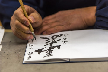 Japanese man writing the name and wishes to a tourist in Japan
