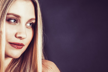 Naklejka premium Beautiful young blonde woman with long straight hair on a dark background 
