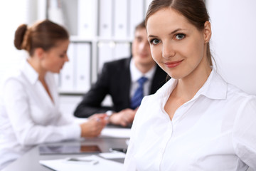 Fototapeta premium Group of business people at meeting on the background of office. Focus on a beautiful brunette