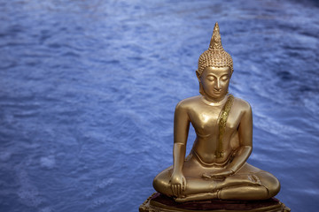 Statue de Bouddha en or avec lac en arrière plan