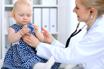 Pediatrician is taking care of baby in hospital. Little girl is being examine by doctor with stethoscope. Health care, medicine and help concept.