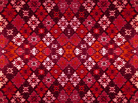 Fragment of ornamental carpet green blue red pink grey violet yellow orange maroon black white turquoise, or abstract surface of tiled rhombus leaves pattern, snowflake texture useful as background
