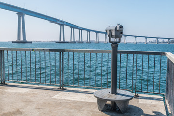 Sightseeing binoculars on the Cesar Chavez Park pier with the San Diego Bay and the Coronado Bridge.
