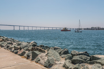 San Diego bay with the Coronado Bridge, sailboat and tugboat from Embarcadero Park South.