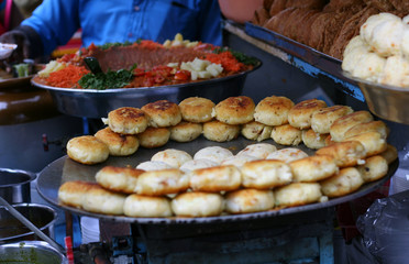 Indian Street food vendor sell Popular kachori on a busy road ,a common scene in public places