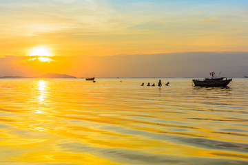 Naklejka na ściany i meble Beach and boat with warm light sunset background