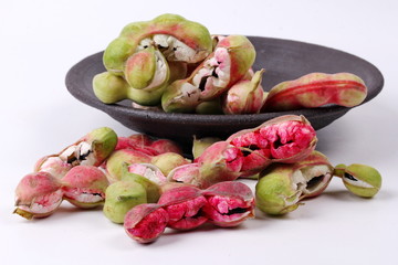 Manila tamarind  fruit on black dish .
