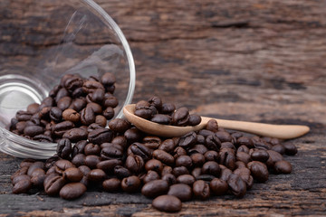 Coffee beans on wood plank with wooden spoon