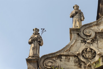 Fototapeta na wymiar Sculptures on the roof of the catholic church