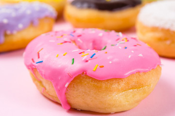 Pink round donut on pastele background. Closeup