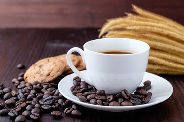 Coffee cup and coffee beans on wooden background