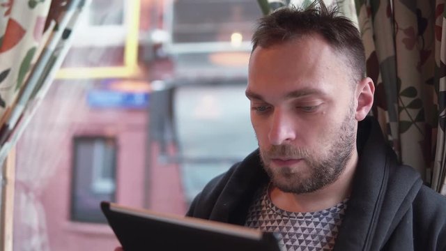 handsome bearded man using tablet computer touchscreen in cafe