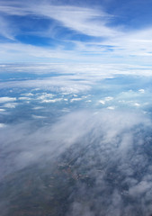 Aerial view on clouds and blue sky from airplane window