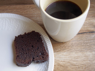 Sliced of chocolate cake with black coffee cup