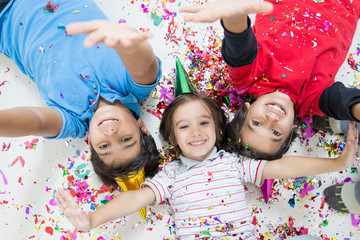 Happy kids celebrating party with blowing confetti