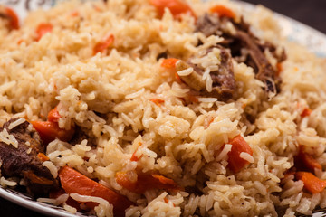 Pilaf on plate with oriental ornament. Central-Asian cuisine - Plov. Macro.