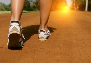 Fototapeta na wymiar close up leg women walking on the road ground. Concept fighting walk forward to target travel