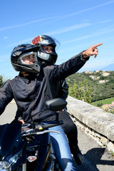 Obraz premium happy young biker couple riding their motorbike in summer
