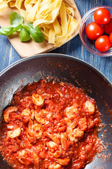 Shrimp with tomato sauce and herbs on a pan