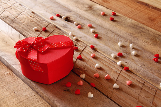 Red hearts and present box on wooden table