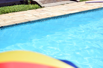 Fototapeta na wymiar Sun umbrella (parasol) in front of a pool