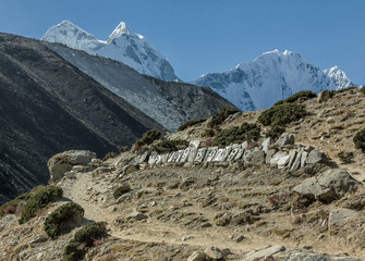 View of the himalayan track with peaks Kantega (6786 m) and Thamserku (6618 m) on background -...