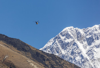 Helicopter on background of the Nuptse wall - Everest region, Nepal, Himalayas