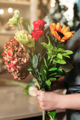 Hands with bouquet closeup at flowers shop.