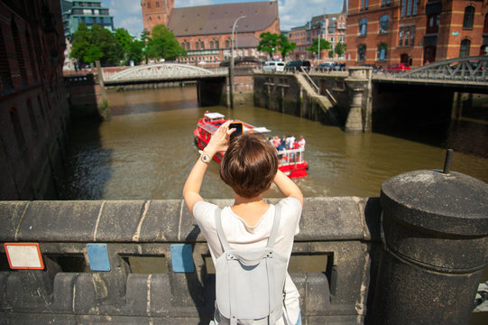 Girl making photo of city using smart phone