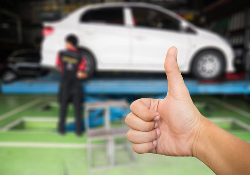 Good hand on blur garage and Mechanic repairing carbackground .