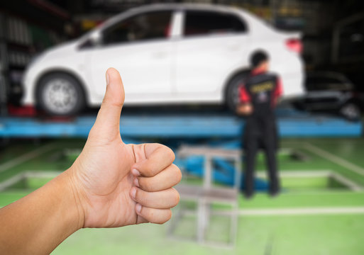 Good hand on blur garage and Mechanic repairing carbackground .