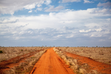Red soil way, blue sky with clouds, scenery of Kenya