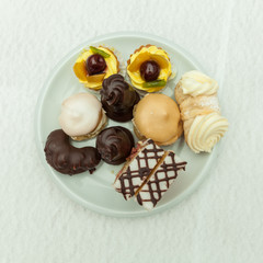 mini cakes on a white plate on the festive table setting to cele