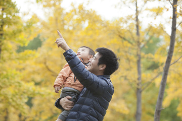Happy real father and son pointing afar