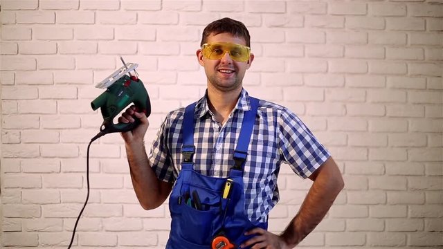 Man with an electric jig saw. Construction worker with a power tool. Working with electric jigsaw.