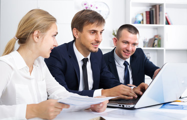 Fototapeta premium Positive business male sitting with coworkers