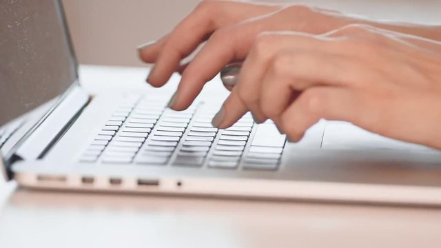 Close-up of a young woman working on a laptop. Slow motion
