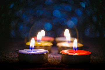 Candle flame light at night with abstract circular bokeh background Christmas lights.