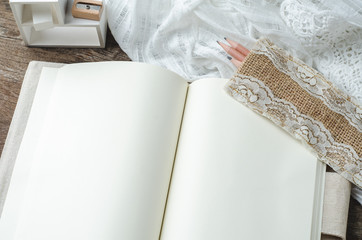Blank notebook with lace on wooden background