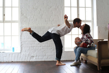 Young happy family relaxing at home on the floor