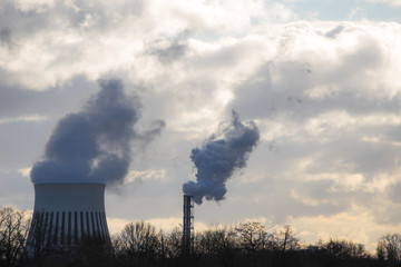 Rauch und Dampf steigen vor wolkigem Himmel aus einem Heizkraftwerk auf