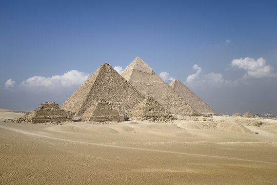 Panoramic view of pyramids from the Giza Plateau (three pyramids known as Queens' Pyramids on front side; next in order from left: the Pyramid of Menkaure, Khafre and Chufu, Cairo, Egypt
