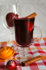 Mulled wine red with cinnamon on table with cloth in plaid